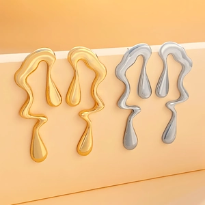 Irregular liquid lava drop earrings in gold and silver finish on geometric stand