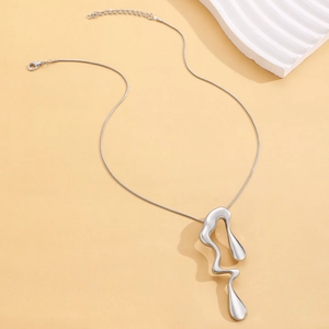 Macro view of silver lava liquid drop pendant and sleek snake chain necklace