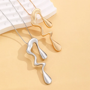 Detailed shot of large liquid metal pendant necklace in gold and silver mirror finish