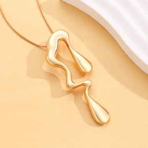 Detailed macro view of liquid gold irregular lava pendant necklace on minimalist background