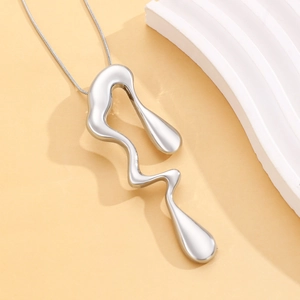Detailed macro view of liquid metal silver pendant with fluid irregular wavy design