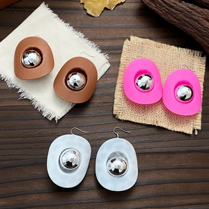 Detailed view of western cowboy hat earrings in brown, pink, and marble white finish