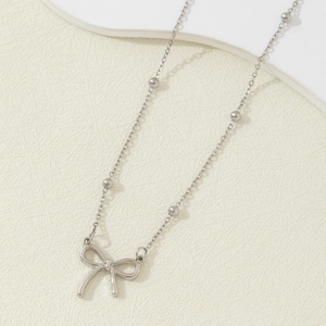 Elegante silberne Metall-Schleifenkette mit feinen Perlen auf minimalistischer Kette
