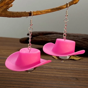 Pink cowboy hat disco ball earrings hanging on a natural branch for party wear