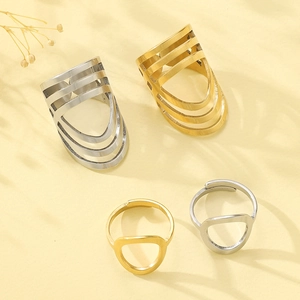 Minimalist oval stainless steel rings set in gold and silver finish on artistic background