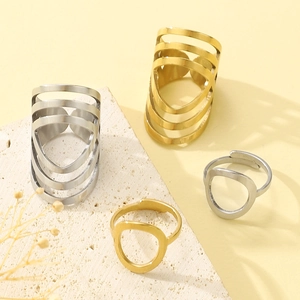 Minimalist gold and silver stainless steel oval rings set on a textured stone base