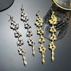 Detailed close-up of long tassel earrings with organic lava texture and water-drop pendants