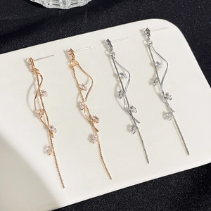 Detailed view of floral tassel earrings with sparkling crystals in gold and silver