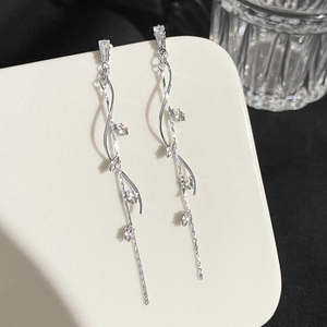 Macro view of crystal flower drop earrings with wavy silver vines and sparkling zircons
