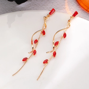 Detail view of long tassel flower earrings with red crystals in golden finish