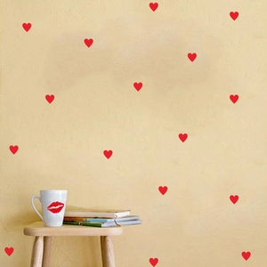 Minimalist red heart wall stickers displayed on a textured warm yellow bedroom wall
