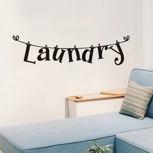 Detail of laundry wall decal featuring a clothesline and pins on a white wall decor