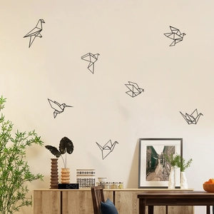 Set of 7 black geometric origami bird wall decals in various flying poses on a home wall
