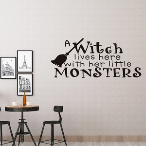 Detail of black witch broom wall sticker with A Witch lives here text on living room wall