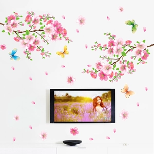 Detail of pink peach blossom wall stickers with butterflies and falling petals for bedroom decor