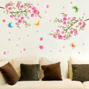 Romantic peach blossom wall decal with colorful butterflies over a living room sofa