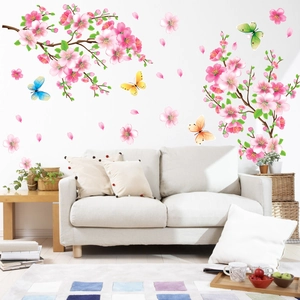 Detail of pink peach blossom wall stickers with colorful butterflies on a white living room wall