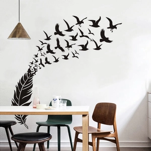 Detailed view of black feather transforming into birds wall decal in a dining room