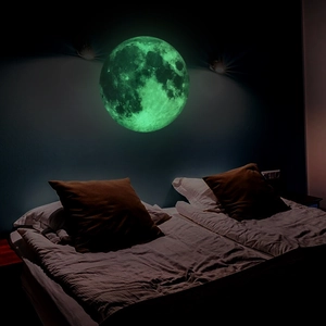 Luminous moon wall sticker with realistic craters glowing bright green in dark bedroom decor