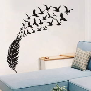 Artistic vinyl wall decal featuring black feather dissolving into flying birds on a white wall