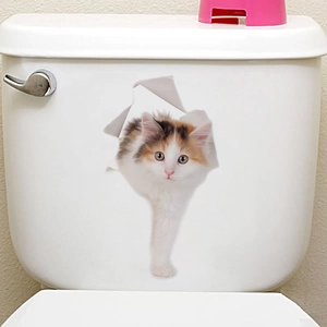 Detail view of a 3D calico cat wall sticker applied to a white ceramic toilet tank surface
