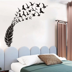 Close-up of black feather and flying birds wall decal over a modern blue headboard