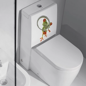 Close-up of 3D green frog wall sticker looking through a magnifying glass on a toilet