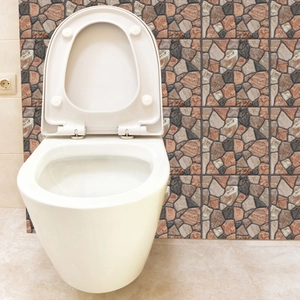 Detail showing the glossy ceramic finish of a modern wall-hung toilet on brick wall