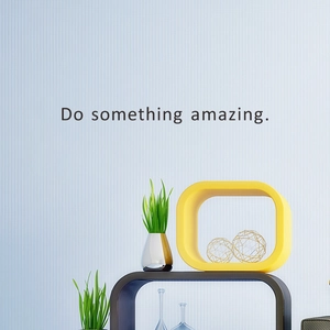 Modern black 'Do something amazing' wall decal in a minimalist office setting