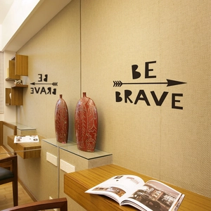 Detail of Be Brave wall sticker with arrow design on a warm beige textured wall