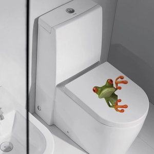 3D green frog wall sticker applied on a white toilet lid for creative bathroom decor