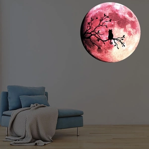 Sticker mural lumineux avec lune rose, silhouette de chat noir et branche sur mur gris