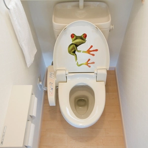 Detailed view of 3D realistic green tree frog decal applied on a modern white toilet lid
