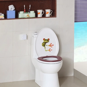 Detailed view of a 3D green tree frog toilet lid sticker with realistic red eyes