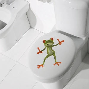 Funny 3D green tree frog decal applied on a white ceramic toilet lid for home decor