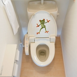 3D cartoon frog sticker applied on a white toilet lid for bathroom wall or appliance decor