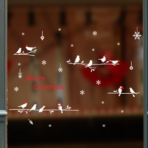 Close-up of Christmas window stickers featuring white birds, snowflakes, and Merry Christmas text