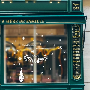 Close-up of white snowflake and Christmas tree static window decals on a shop glass
