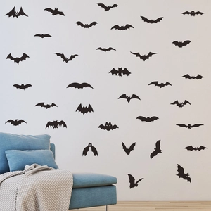 Nahaufnahme von 3D Fledermaus-Wandstickern an einer weißen Wand über einem blauen Sofa