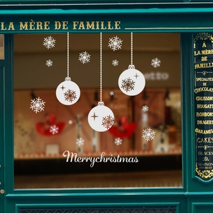 White Christmas window decals with snowflakes and festive hanging ornaments on glass
