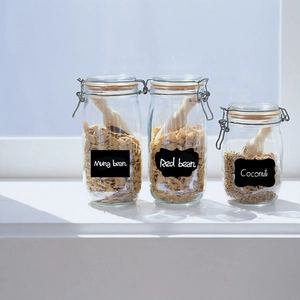 Close-up of blackboard label stickers on glass storage jars with wooden spoons