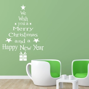 Detail showing white Christmas tree wall sticker with festive wishes on a green wall