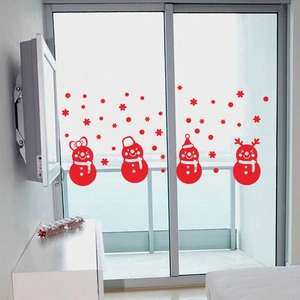Detail view of red Christmas snowman and snowflake window stickers on glass sliding doors