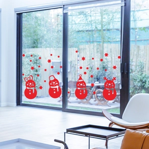 Detail of red Christmas snowman and snowflake window decals on a large glass sliding door