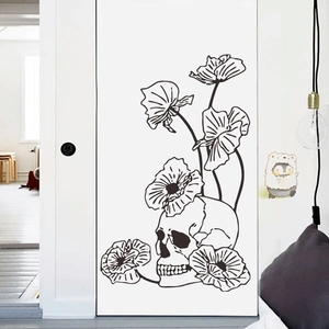 Detail of artistic black skull and poppy flower wall sticker on a white interior door