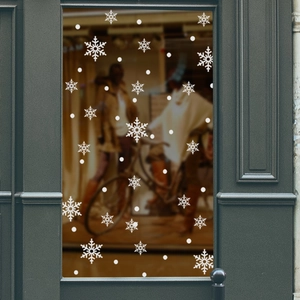 Close-up of white snowflake static stickers on a glass window for Christmas decor