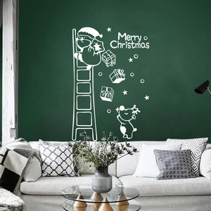 White Christmas wall decals with Santa on ladder over green wall in a cozy living room