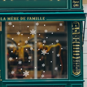 White Christmas snowflake window stickers set on dark green vintage storefront background