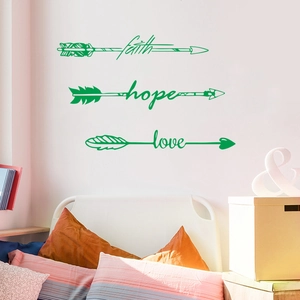 Detail of green vinyl wall stickers with faith hope love arrow quotes over a white bed