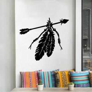 Tribal Indian style wall sticker with arrow and feathers above a sofa with pillows